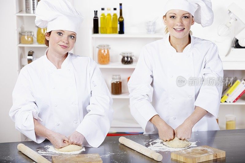 两名白人厨师/面包师在专业厨房里准备生面团